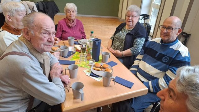 Menschen sitzen an einem Tisch.