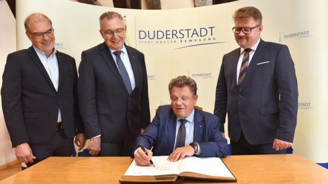 Minister Dr. Philippi trägt sich in das Goldene Buch der Stadt Duderstadt ein im Beisein der Caritas-Vorstände Holger Gatzenmeyer (l.) und Ralf Regenhardt sowie Bürgermeister Thorsten Feike (r.). | Foto: Iris Blank / kpvd